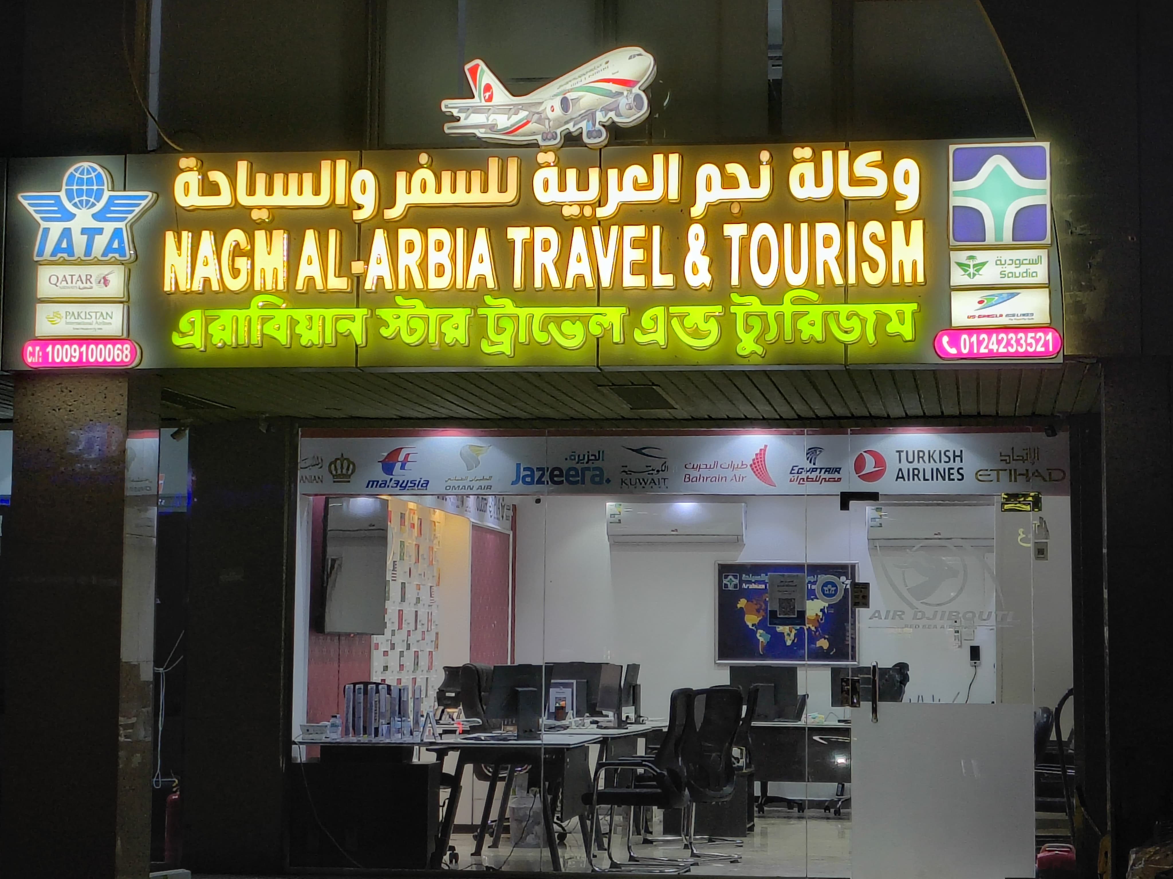Illuminated Nagm Al-Arbia travel agency storefront